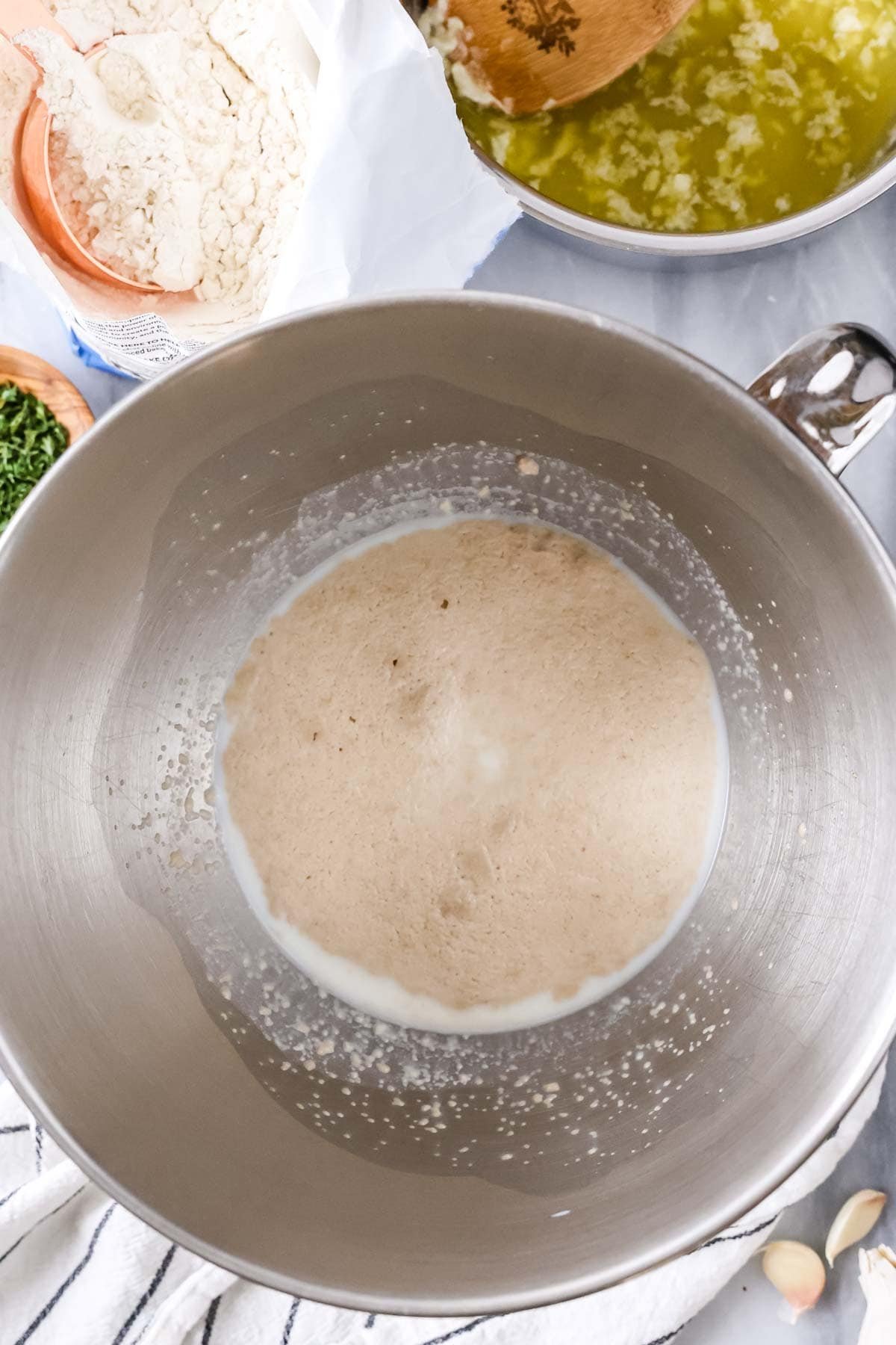 Overhead view of foamy yeast in a mixing bowl.