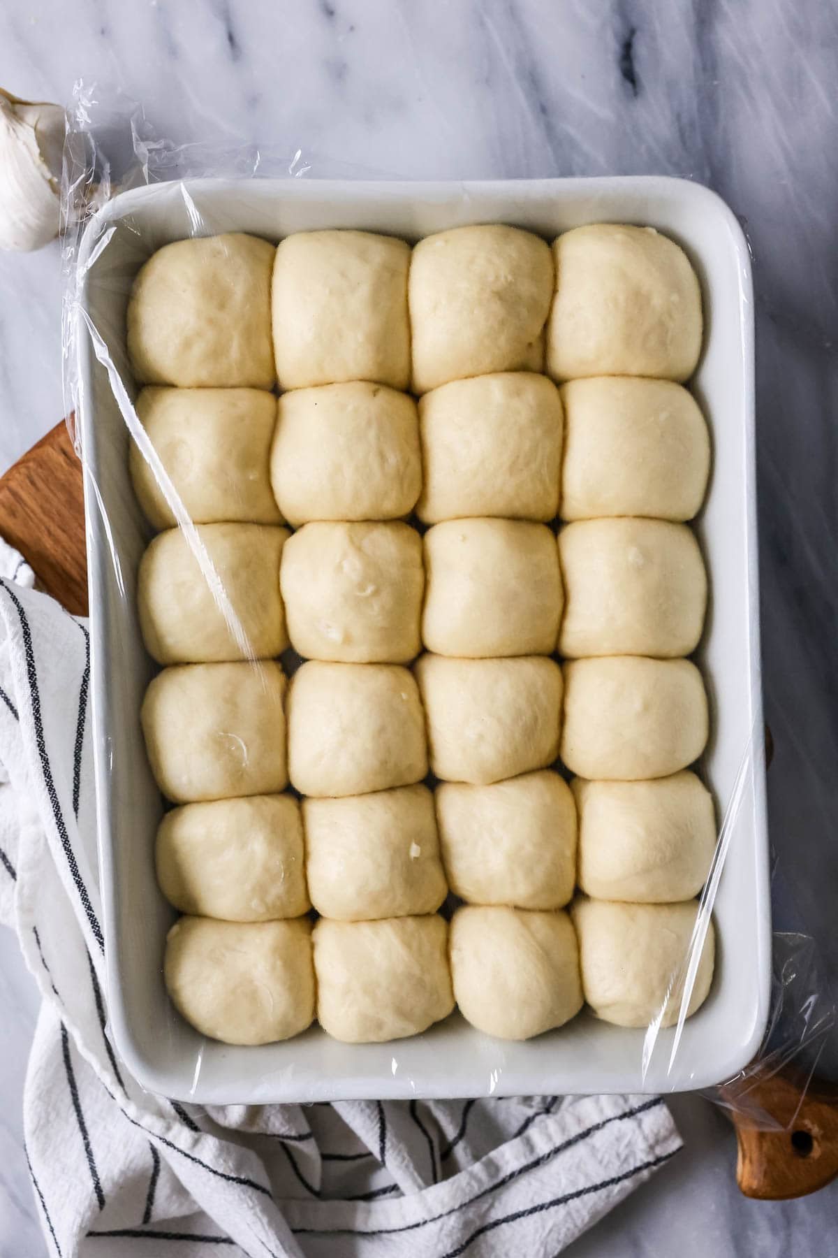 Overhead view of dinner rolls in a baking dish after rising.