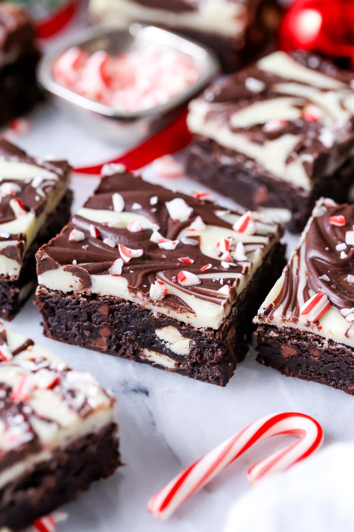 Close-up view of peppermint bark brownies with swirled ganache tops.