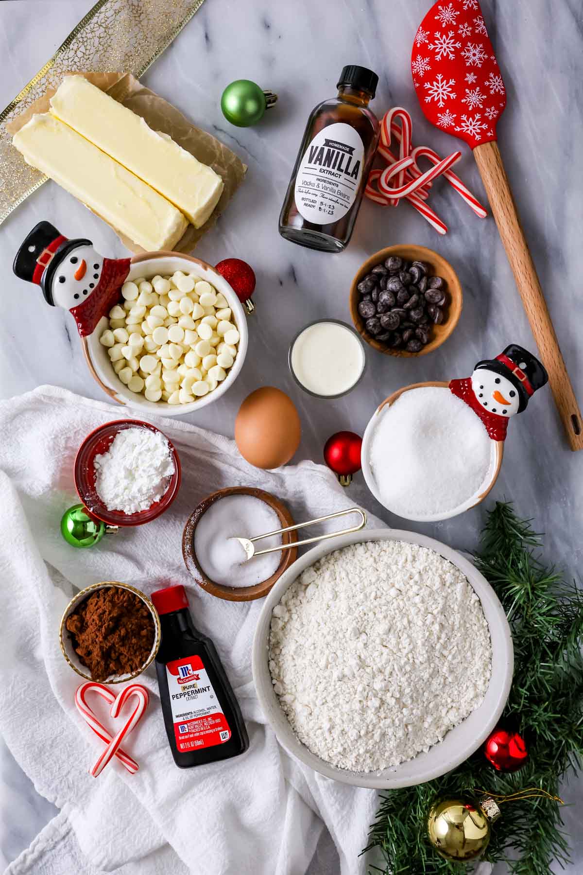 Overhead view of ingredients including cocoa powder, white chocolate, candy canes, and more.