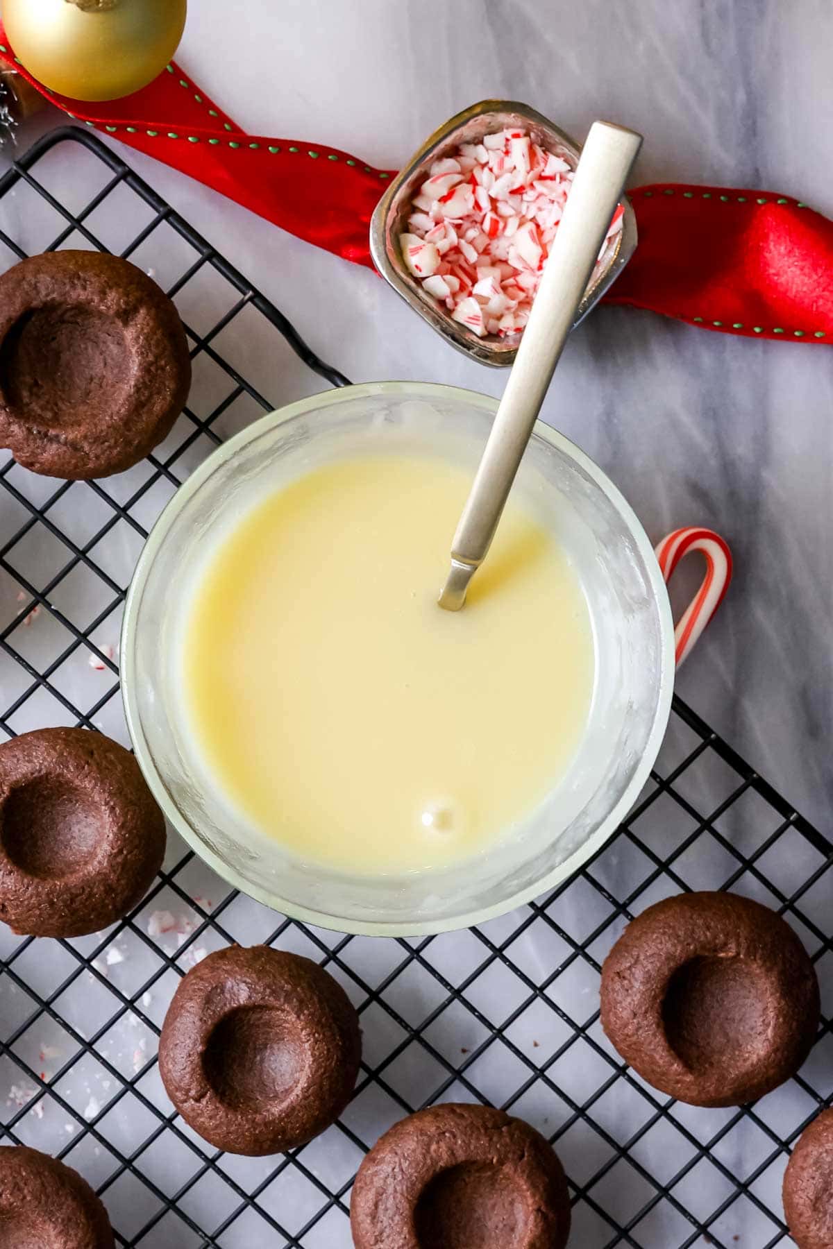 Bowl of melted white chocolate for filling thumbprint cookies.