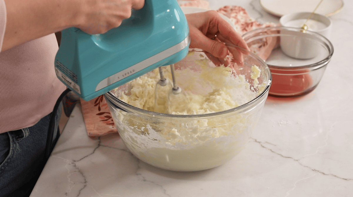 Mixing buttercream with an electric mixer.