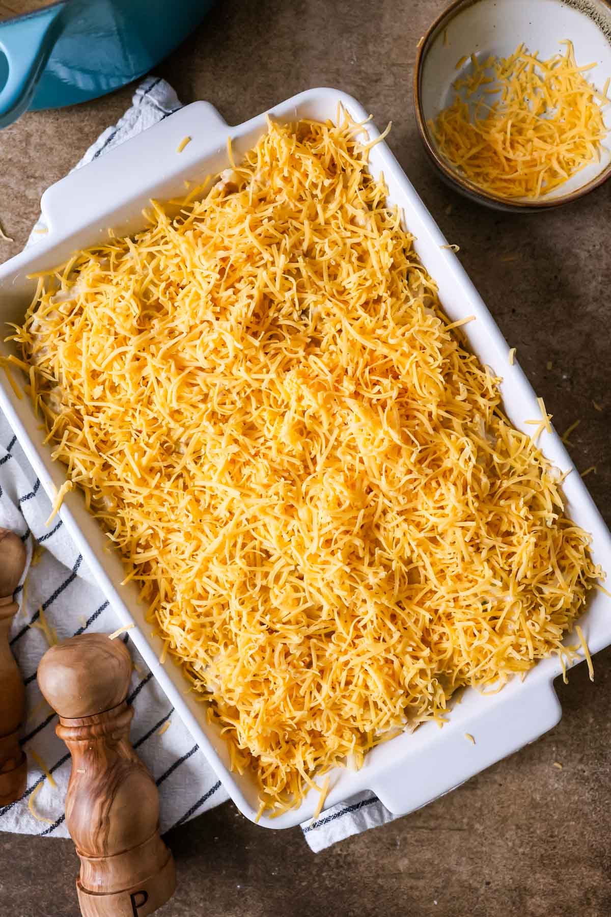 Overhead view of a cheese topped casserole before baking.