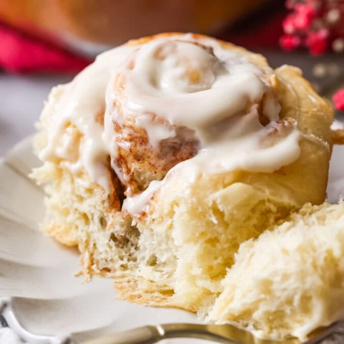 Close up of Amish cinnamon roll that's been cut into with fork showing fluffy, gooey, cinnamon-y interior.
