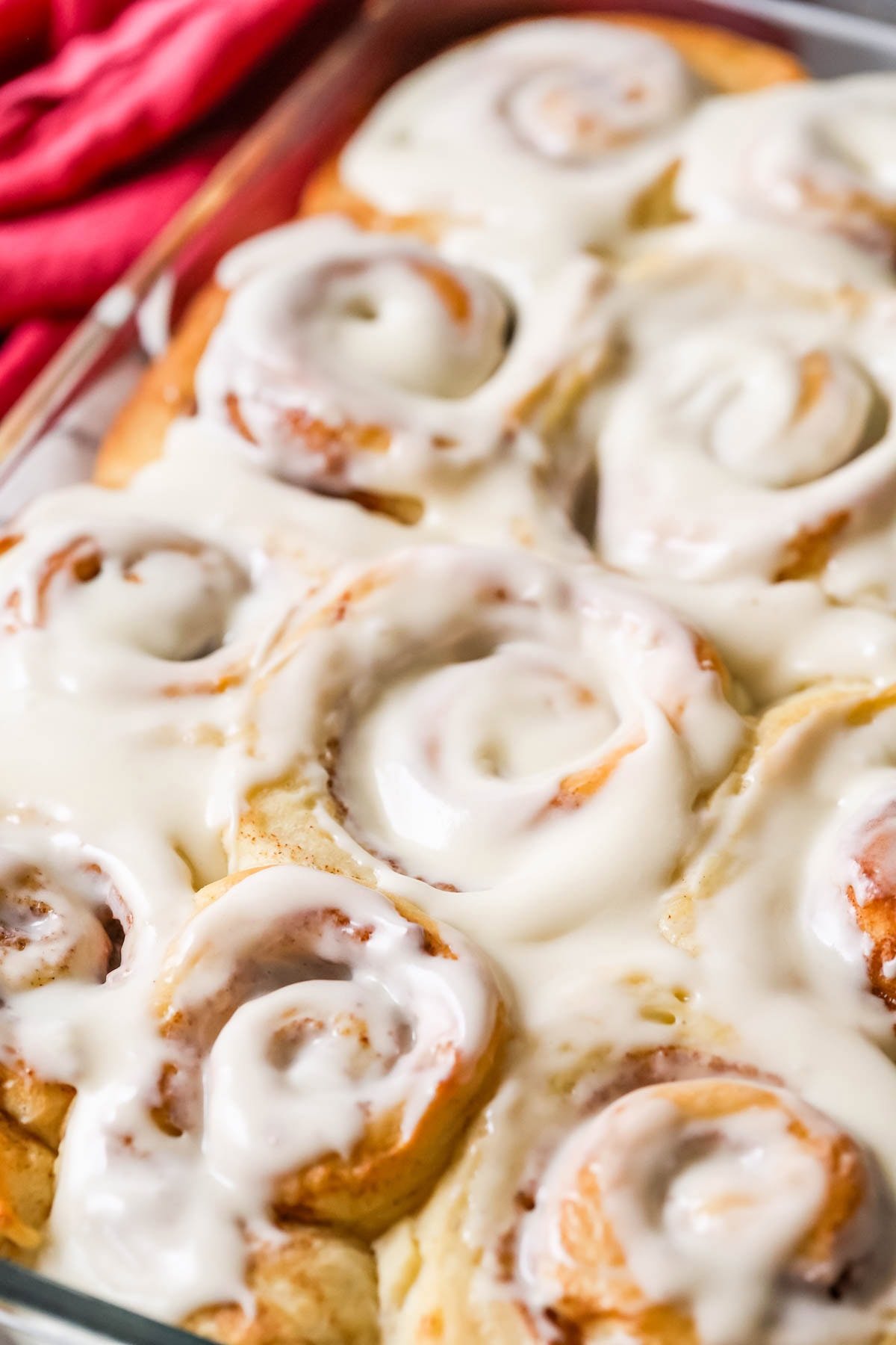 Close up of baking dish full of Amish cinnamon rolls with cream cheese icing.