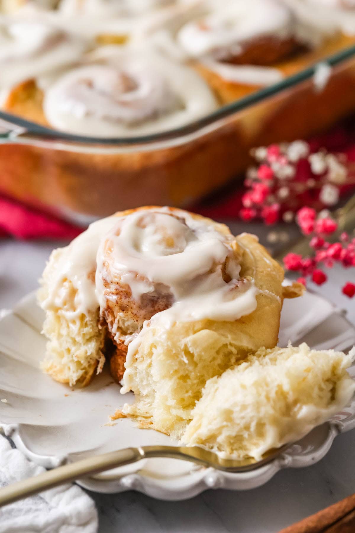 Close up of Amish cinnamon roll that's been cut into with fork showing fluffy, gooey, cinnamon-y interior.