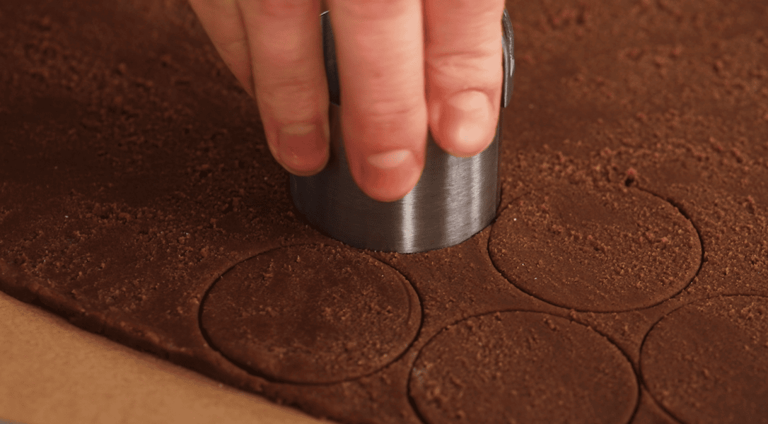 Cutting out circles in chocolate craquelin dough.