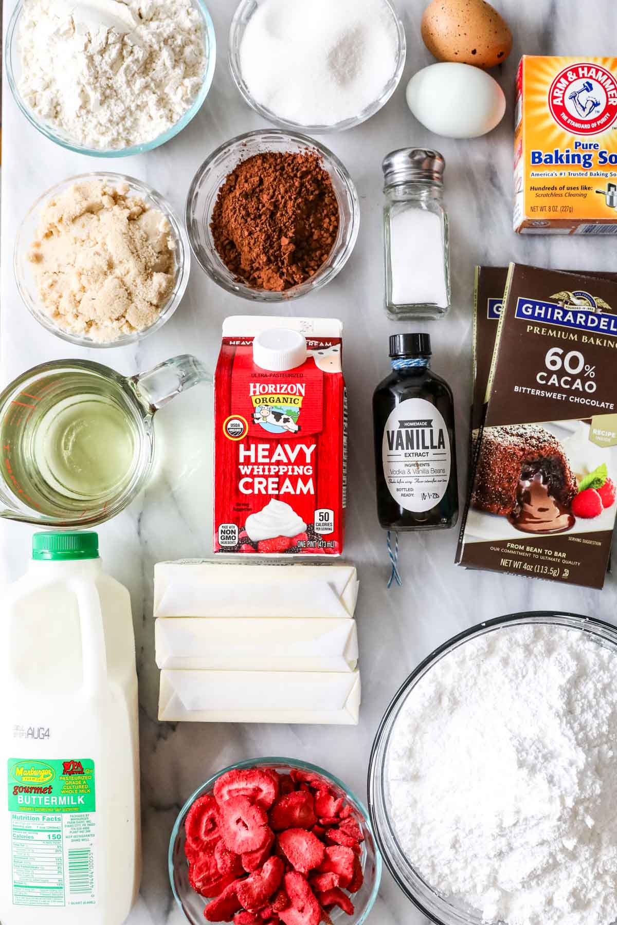 Overhead view of ingredients including chocolate, freeze dried strawberries, cream, and more.