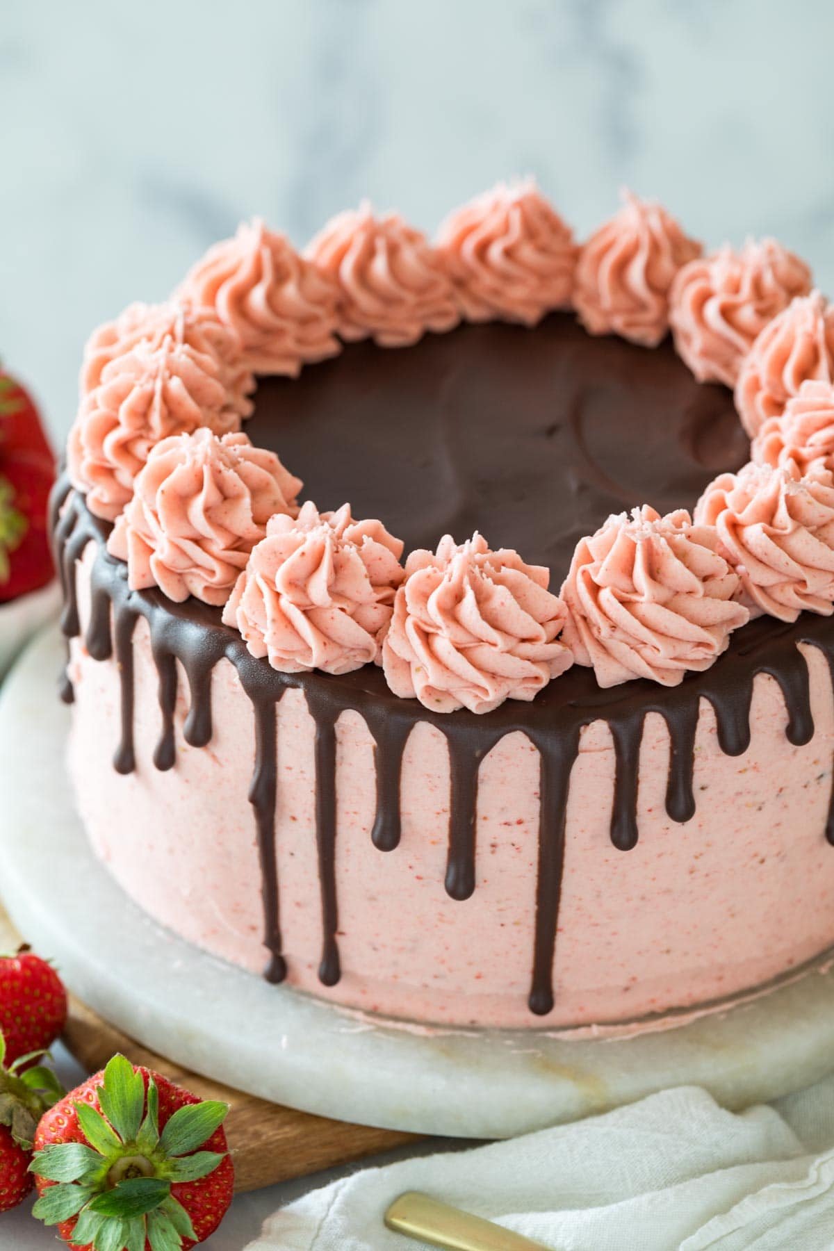 Chocolate strawberry cake decorated with a pink strawberry frosting and a ganache drip.