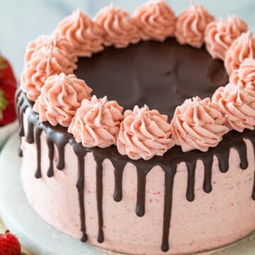 Chocolate strawberry cake decorated with a pink strawberry frosting and a ganache drip.
