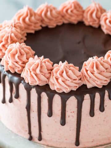 Chocolate strawberry cake decorated with a pink strawberry frosting and a ganache drip.