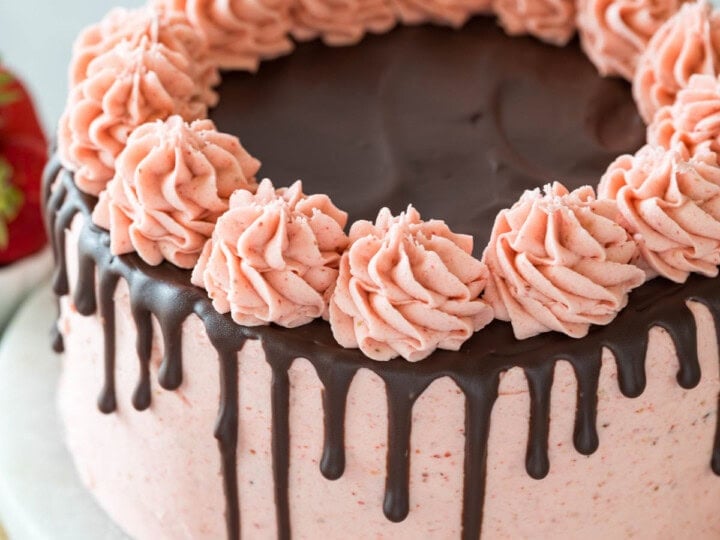Chocolate strawberry cake decorated with a pink strawberry frosting and a ganache drip.