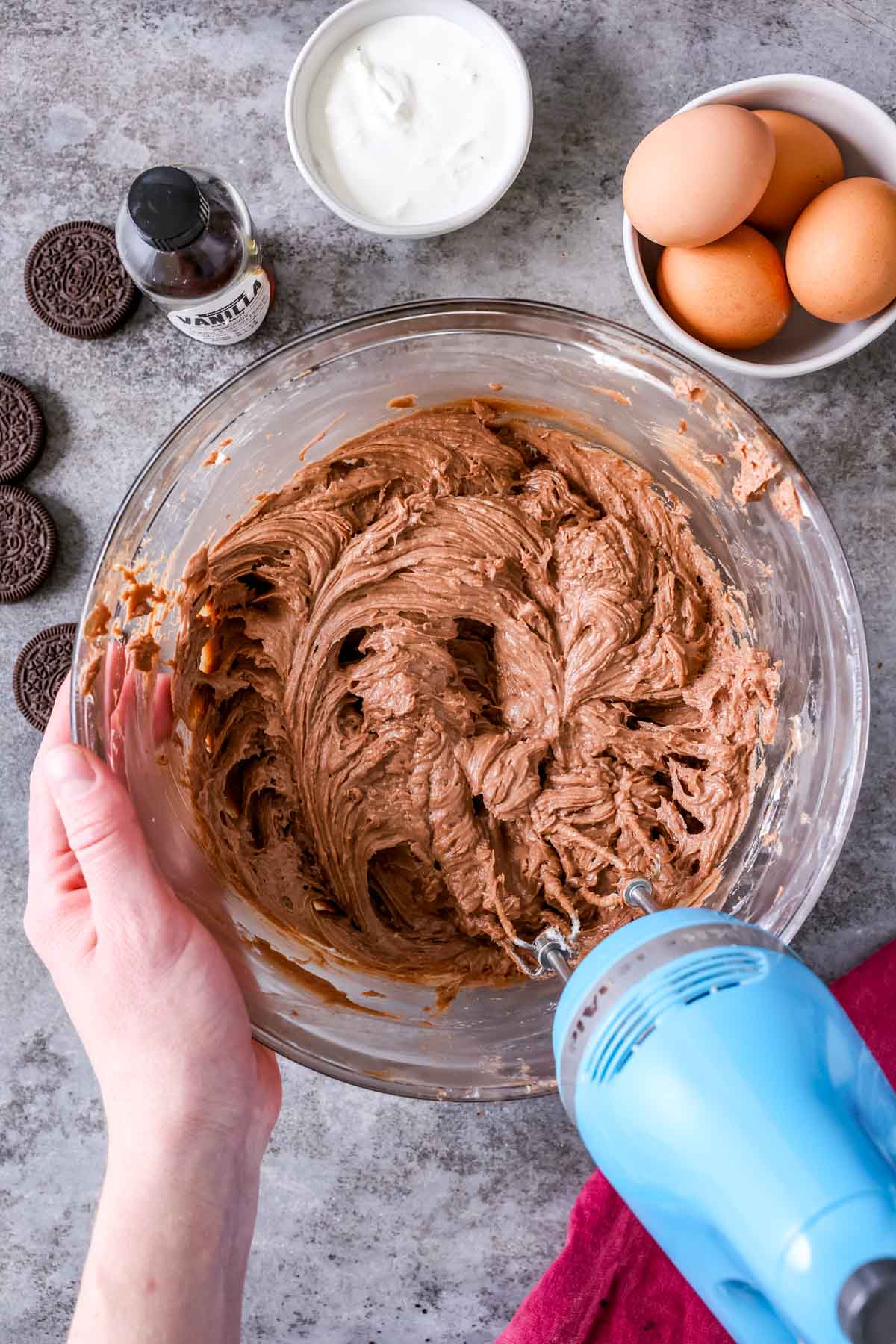 Overhead view of a Nutella and cream cheese mixture being mixed with an electric mixer.