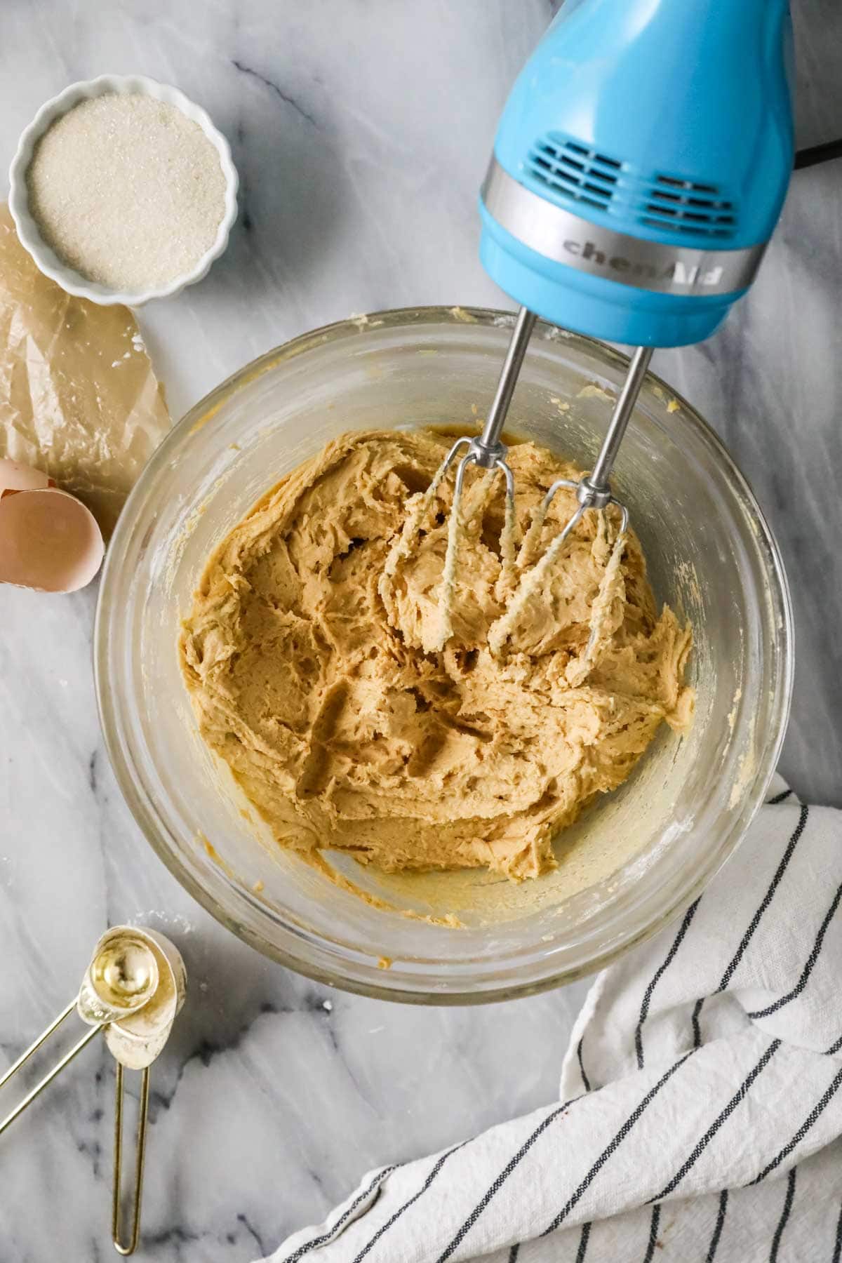 Overhead view of cookie dough in a bowl after being mixed with a hand mixer.