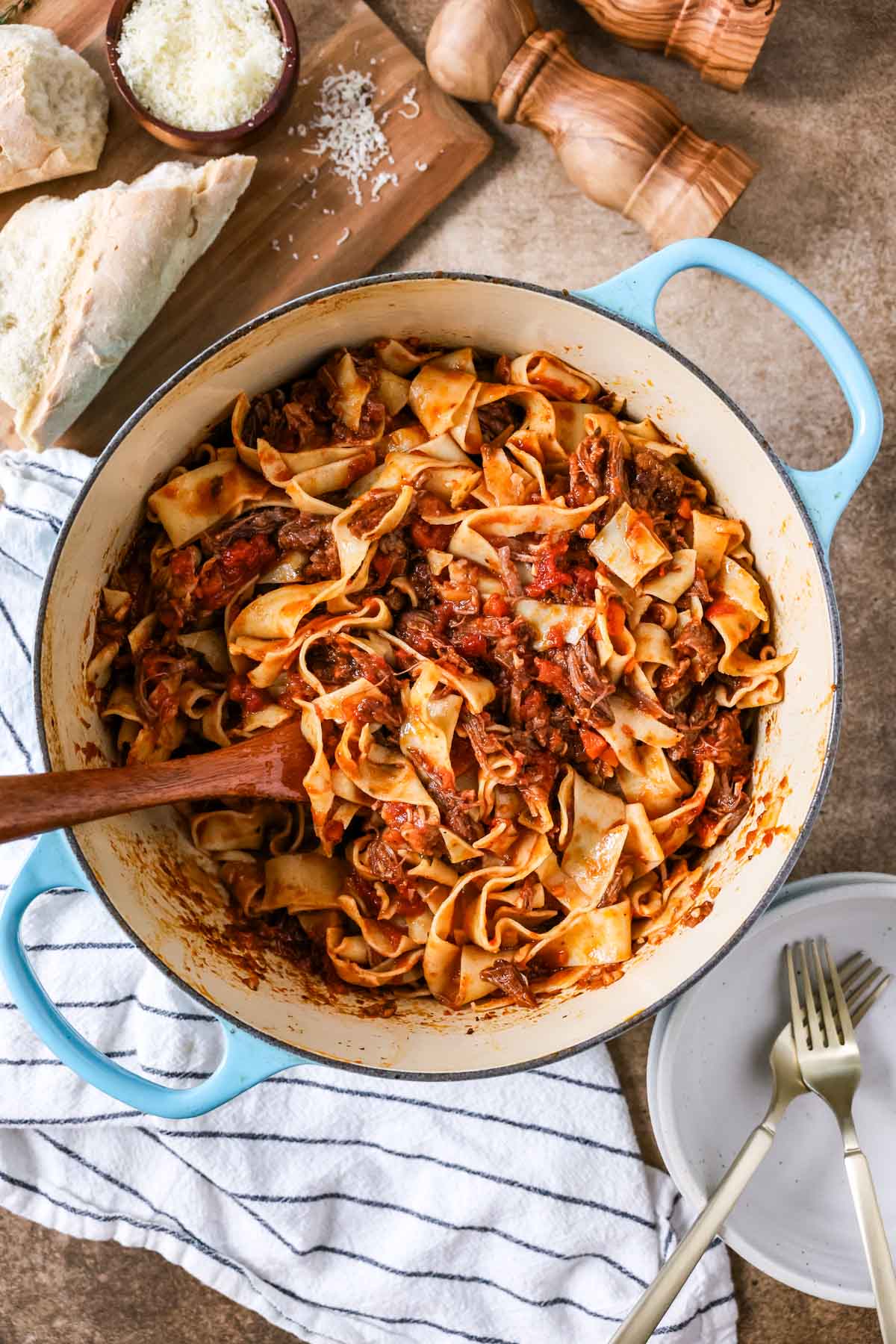Overhead view of a pot of short rib ragu tossed witih pappardelle pasta.