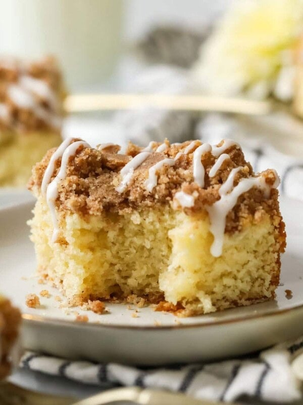 Bite missing from a slice of sourdough coffee cake on a white plate.