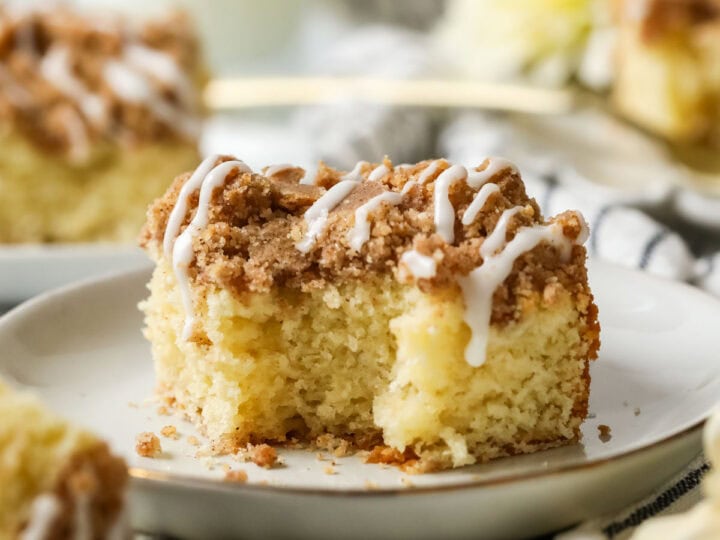 Bite missing from a slice of sourdough coffee cake on a white plate.