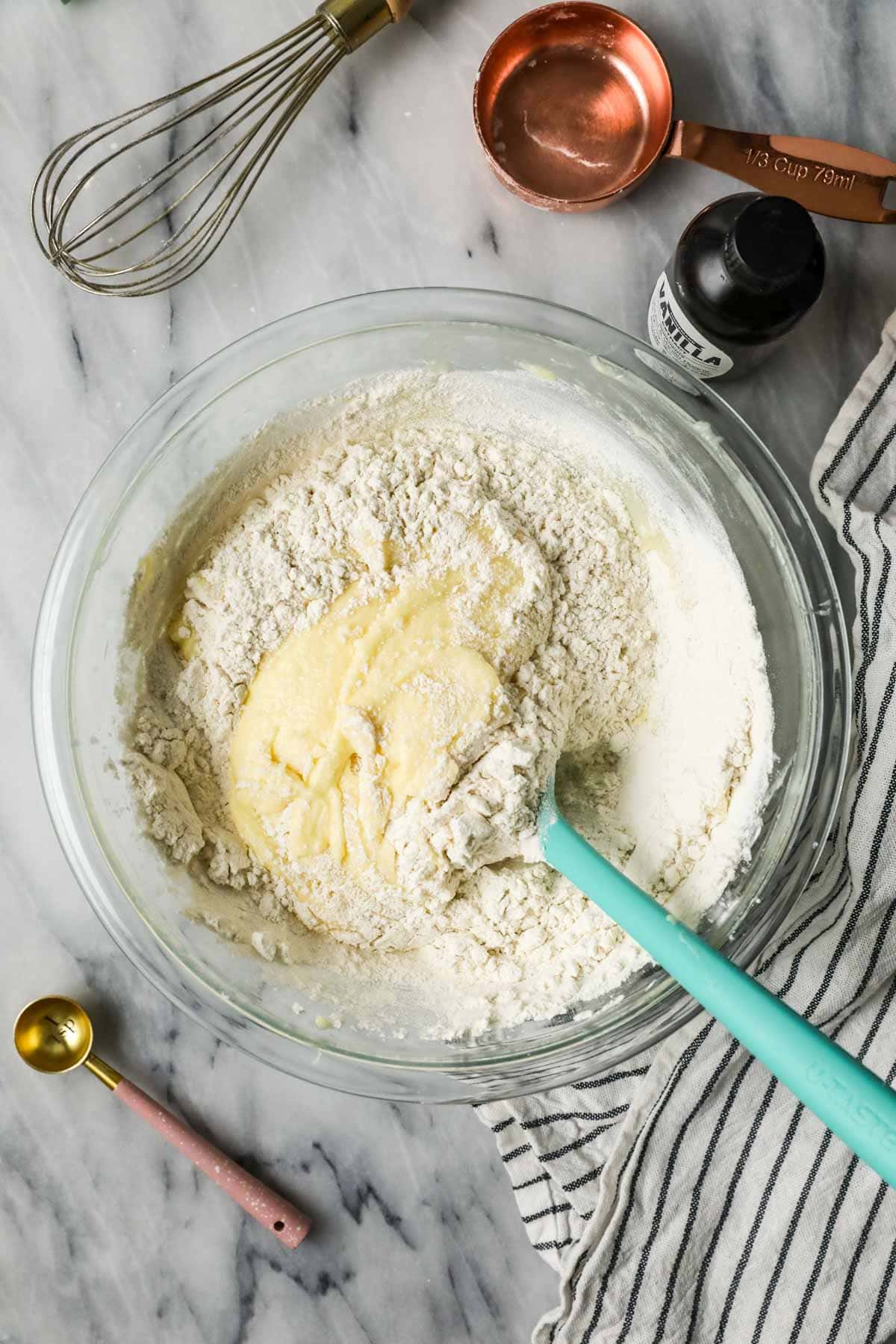 Overhead view of dry ingredients being folded into a coffee cake batter.