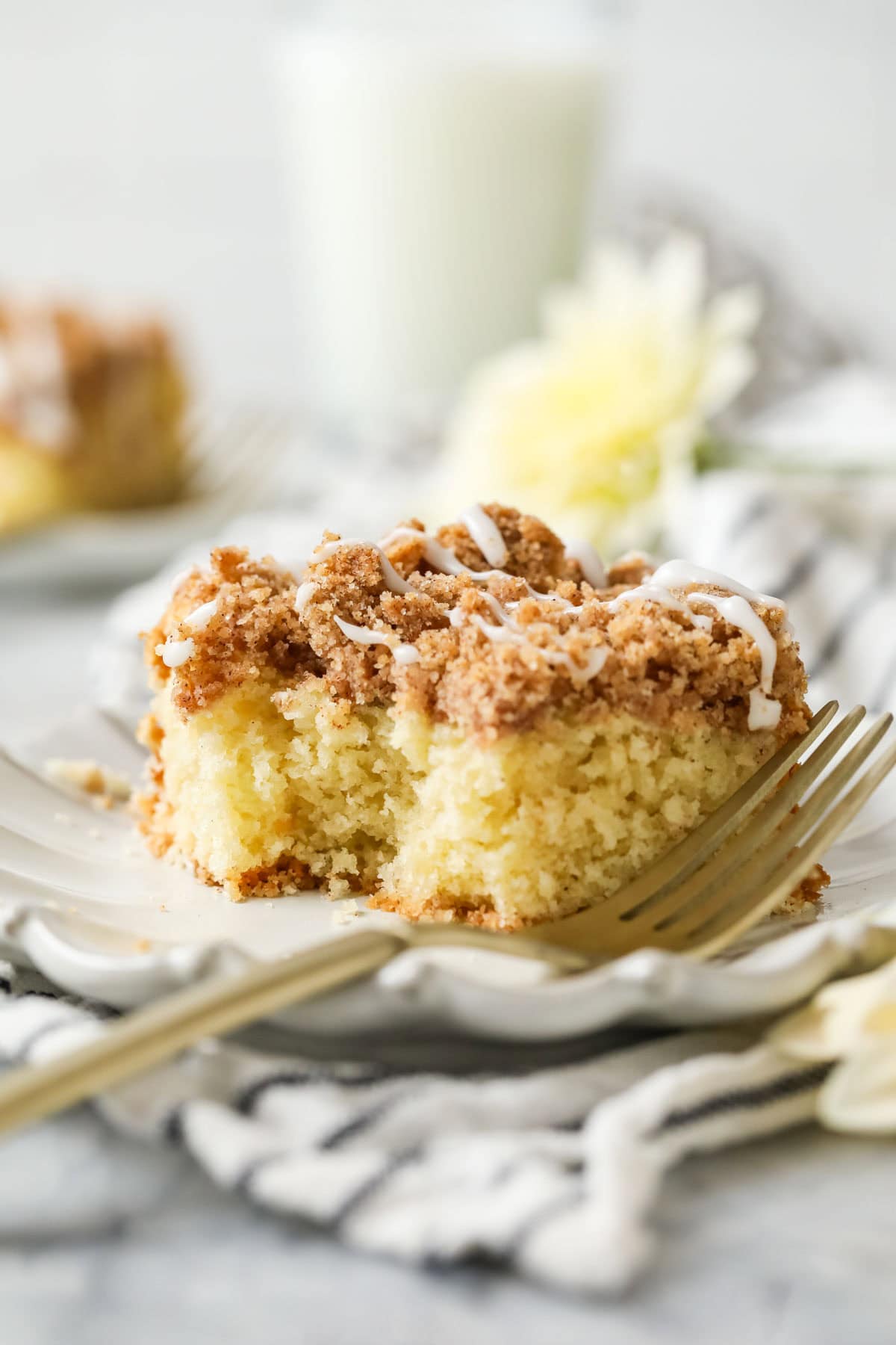 Fork beside a slice of sourdough coffee cake on a white plate.