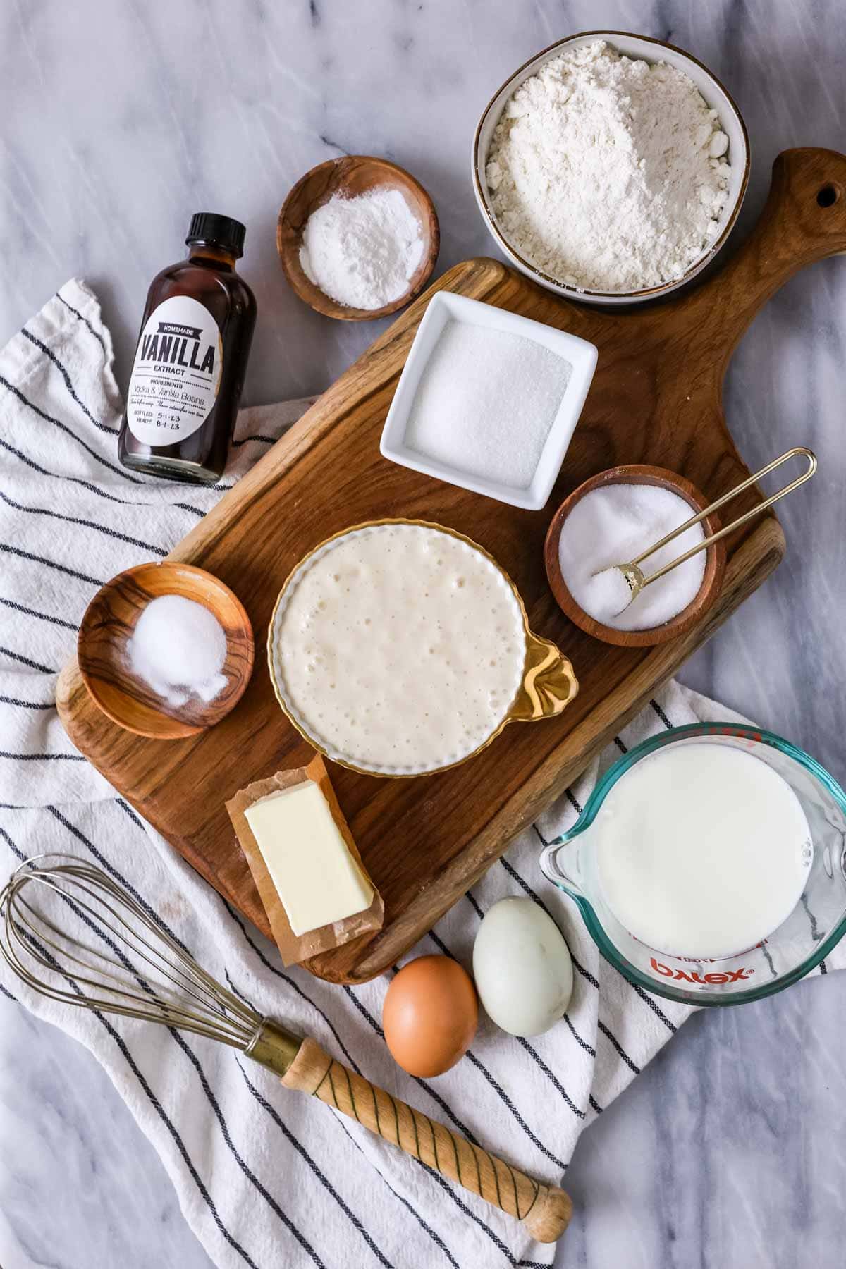 Overhead view of ingredients including sourdough starter, milk, eggs, and more.