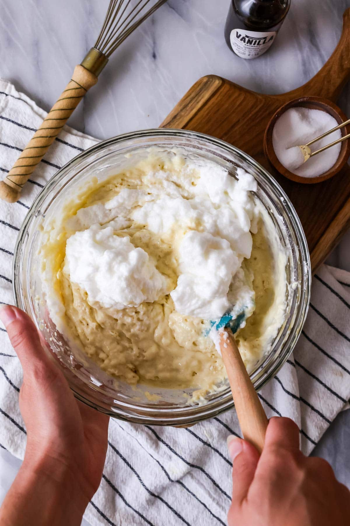 Overhead view of folding whipped egg whites into waffle batter.