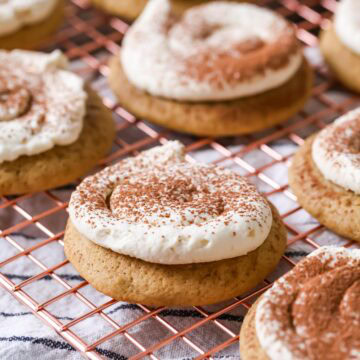 Tiramisu cookies made with espresso soaked cookies and a mascarpone frosting on a cooling rack.