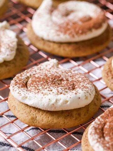Tiramisu cookies made with espresso soaked cookies and a mascarpone frosting on a cooling rack.