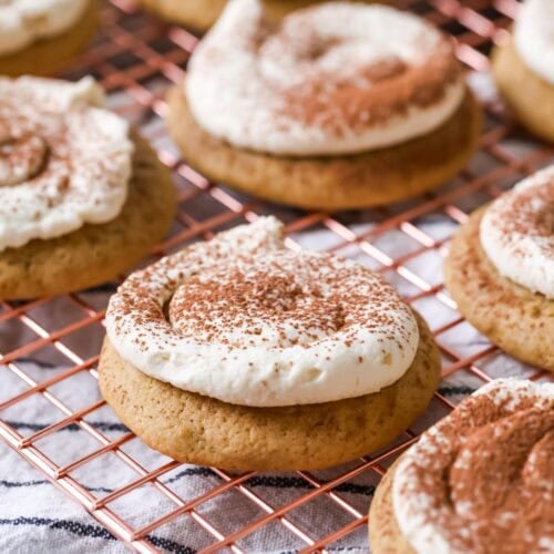 Tiramisu cookies made with espresso soaked cookies and a mascarpone frosting on a cooling rack.