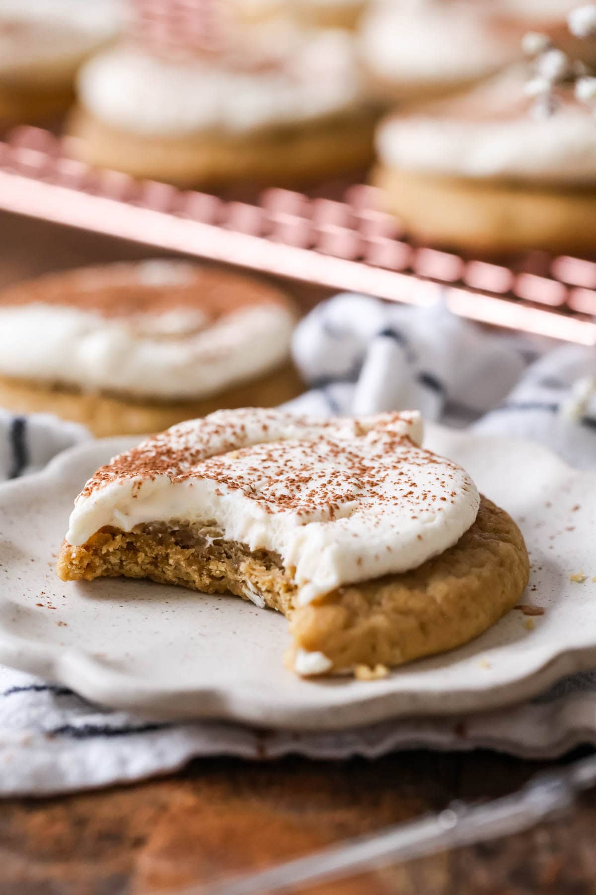 Bite missing from a tiramisu cookie on a white plate.
