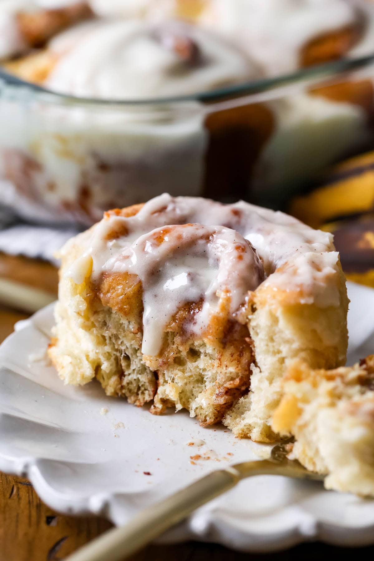 Close-up view of a banana bread cinnamon roll that's been cut in half to show a fluffy interior.