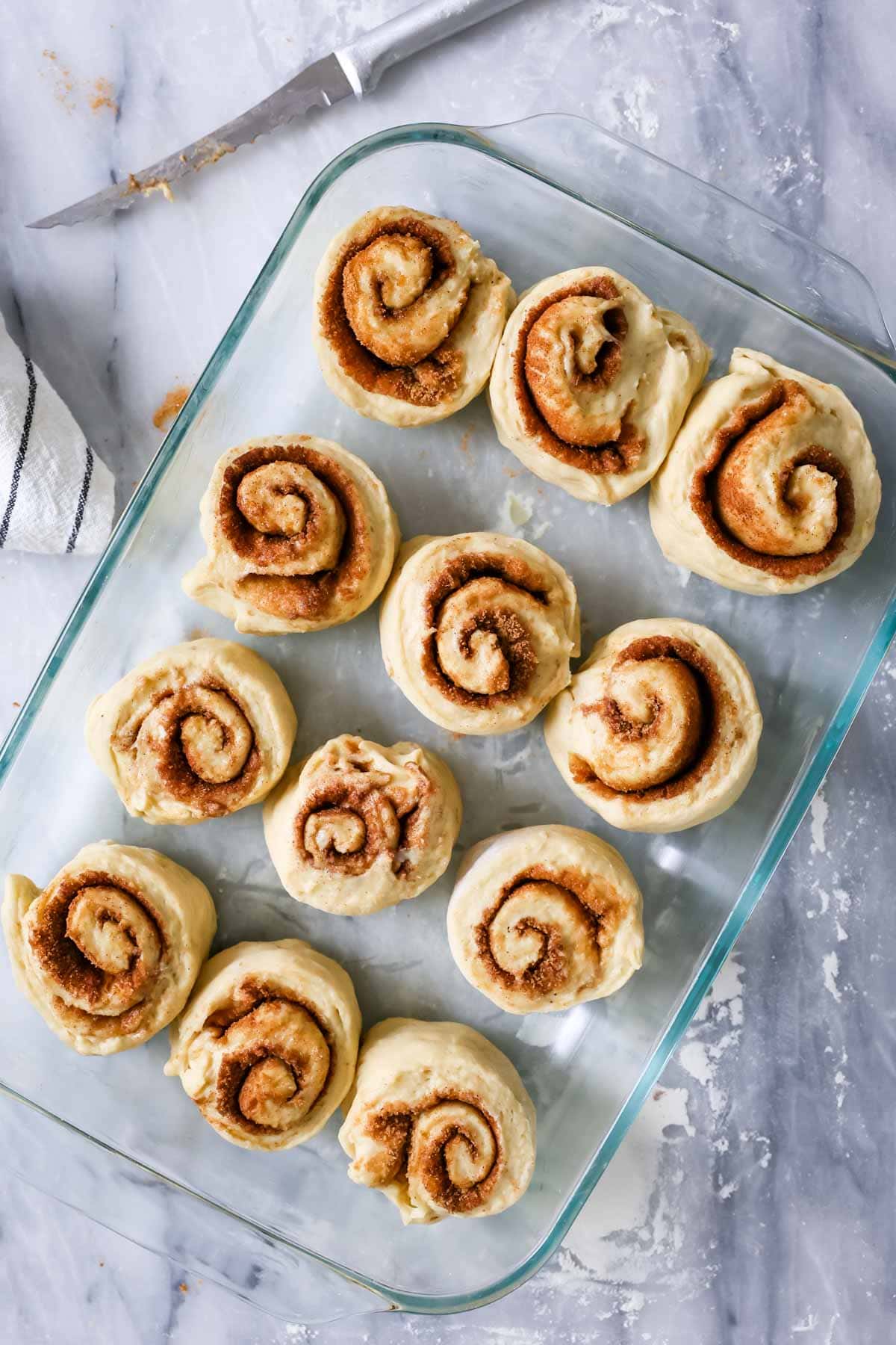 Overhead view of banana cinnamon rolls in a pan before rising.