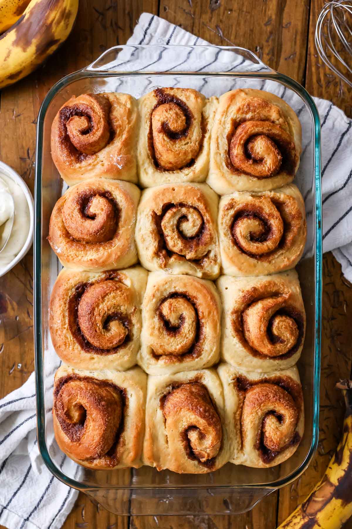 Overhead view of baked cinnamon rolls in a pan before frosting.