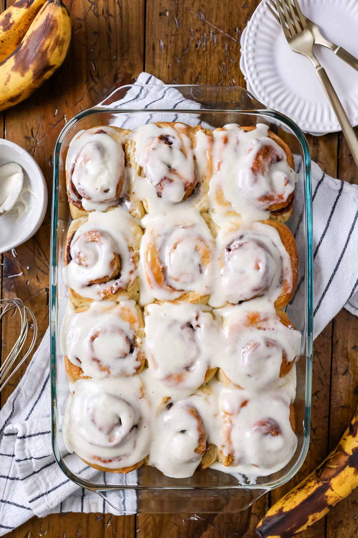 Overhead view of a pan of iced banana bread cinnamon rolls.