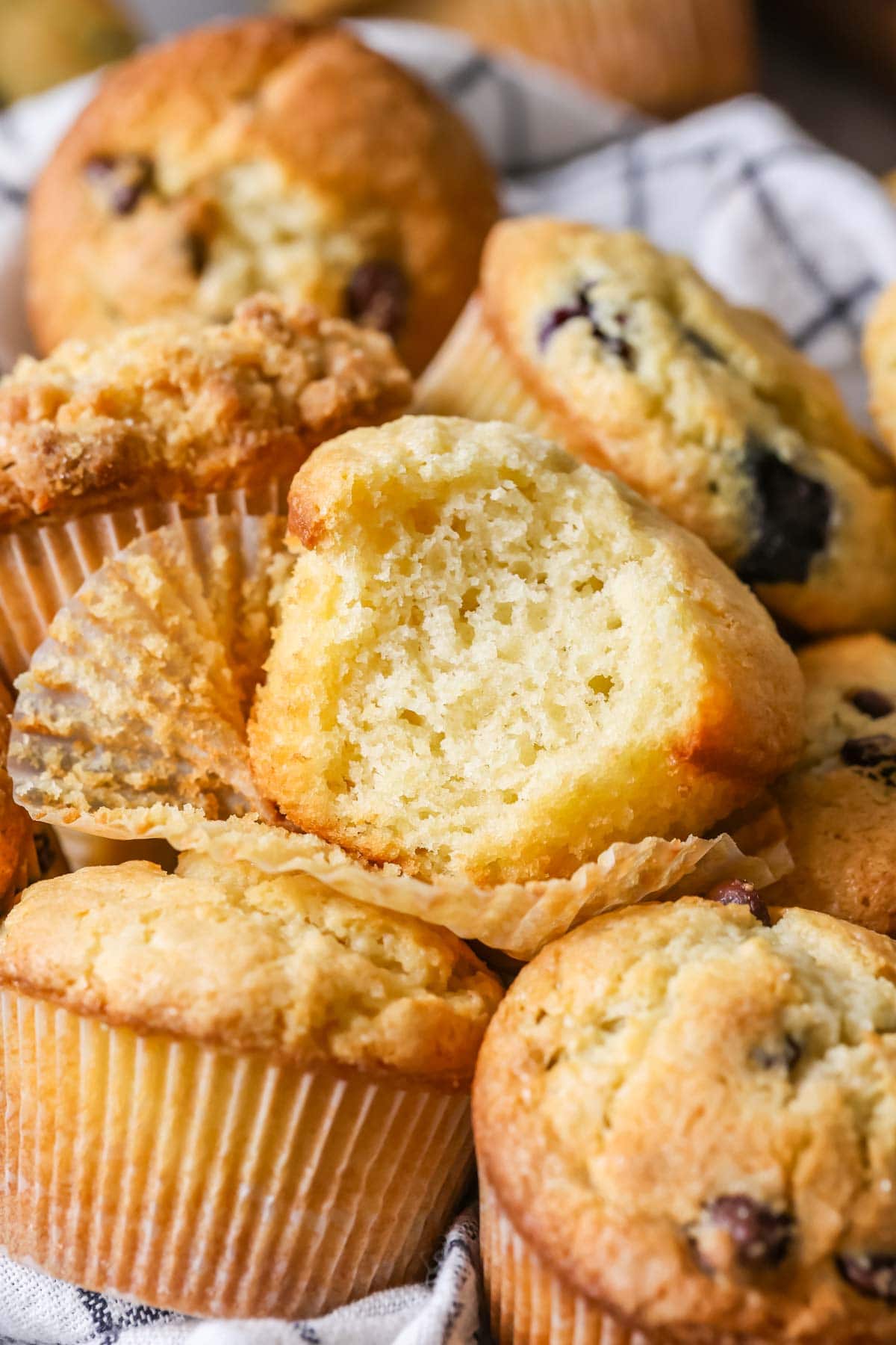 Bite missing from a muffin surrounded by other muffins.