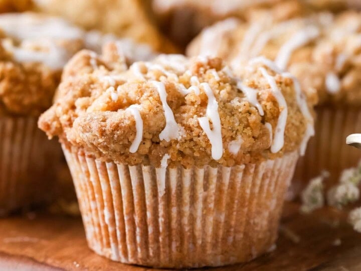 Close-up view of coffee cake muffins drizzled with a vanilla glaze.