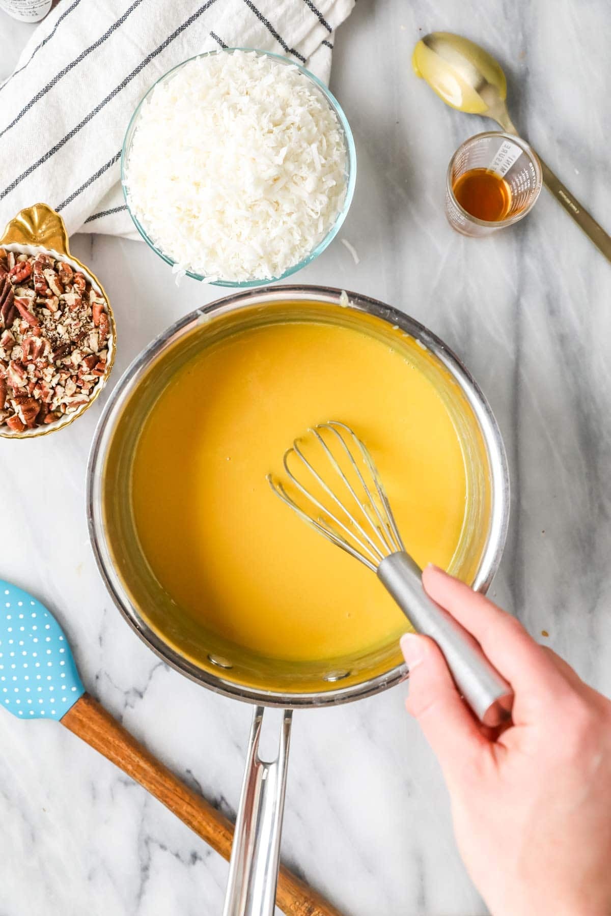 Thickened caramel being stirred with a whisk.