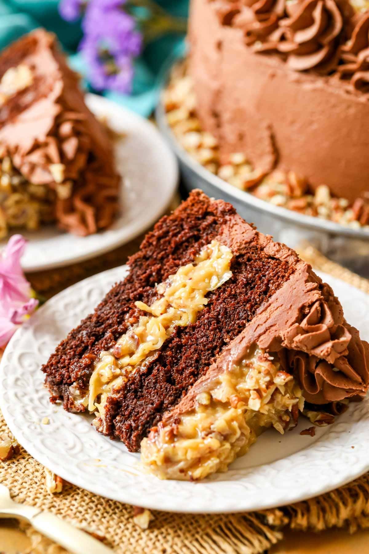 Slice of cake made with two layers of chocolate cake, a coconut caramel filling, and chocolate frosting.