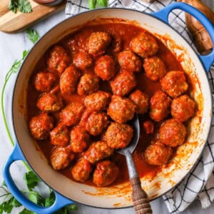 Overhead view of meatballs and tomato sauce in a skillet.