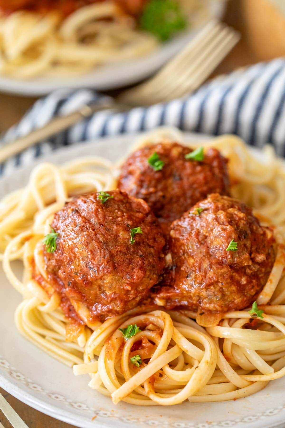 Plate of spaghetti topped with meatballs.