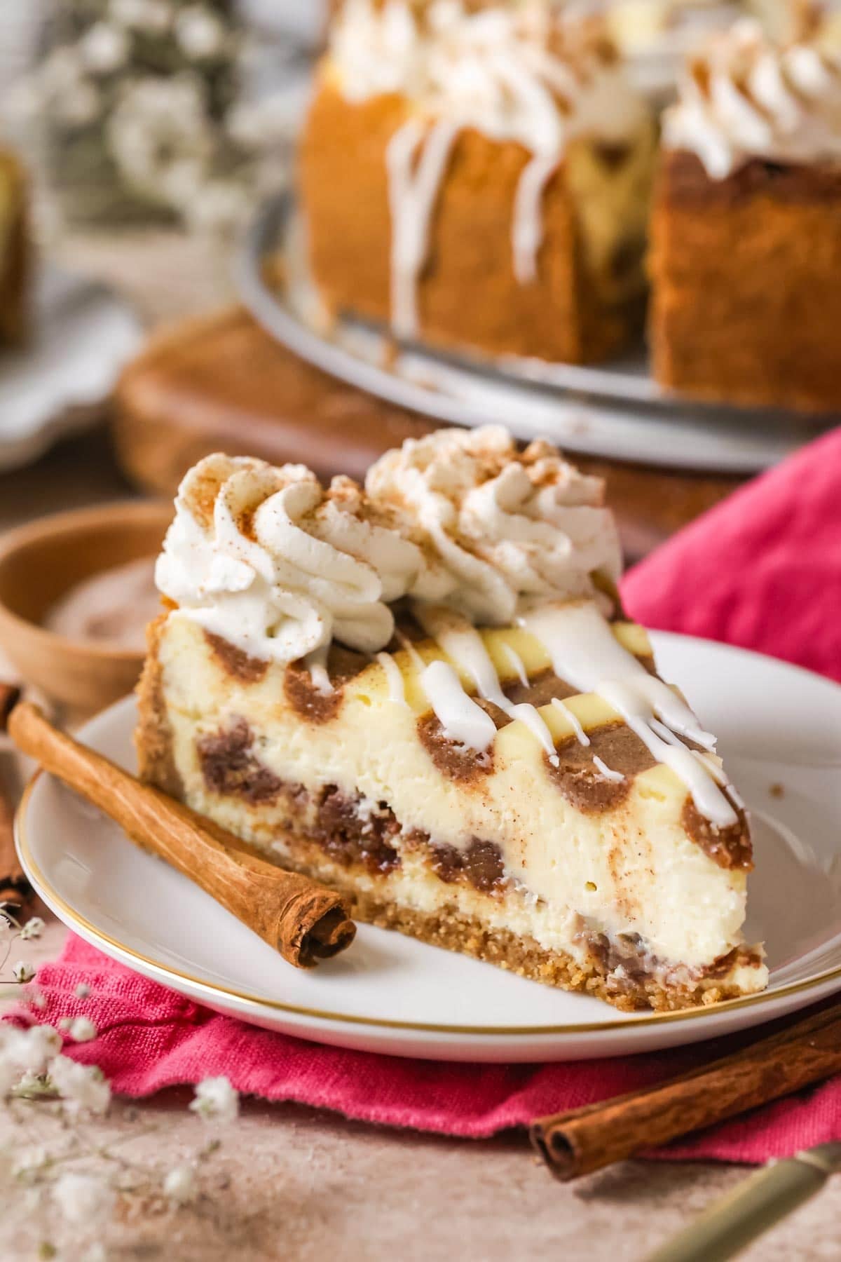 Slice of cinnamon roll cheesecake on a plate.