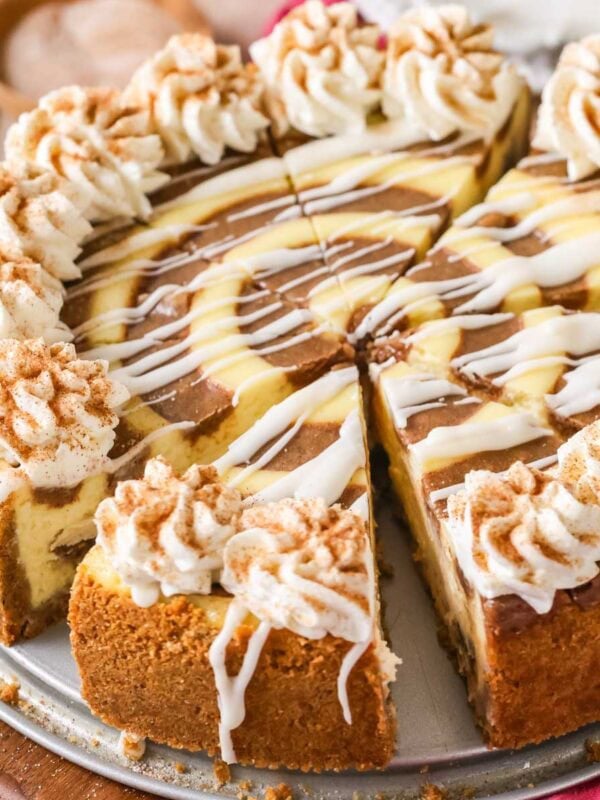 Close-up view of a cinnamon roll cheesecake that's been cut into slices.