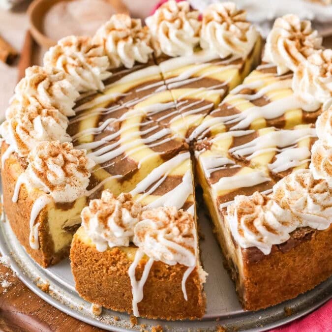 Close-up view of a cinnamon roll cheesecake that's been cut into slices.