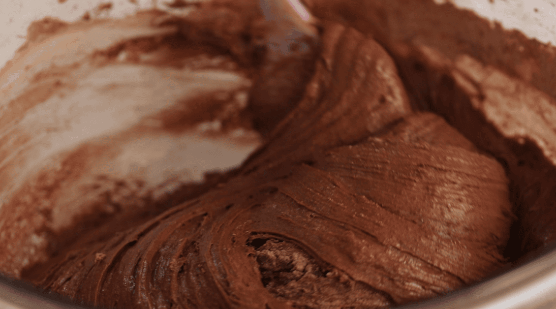 Stirring brownie cookie dough with a spatula.
