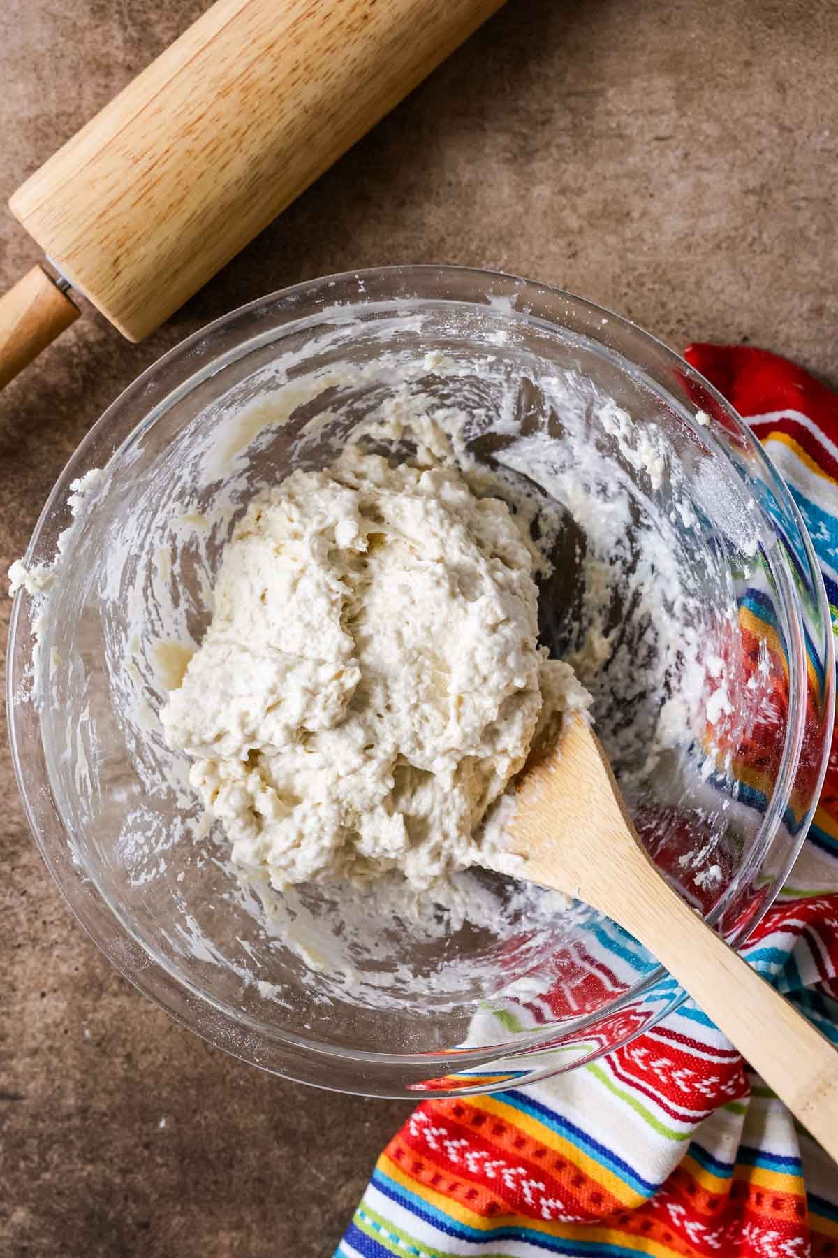 Overhead view of a bowl with a shaggy dough inside.