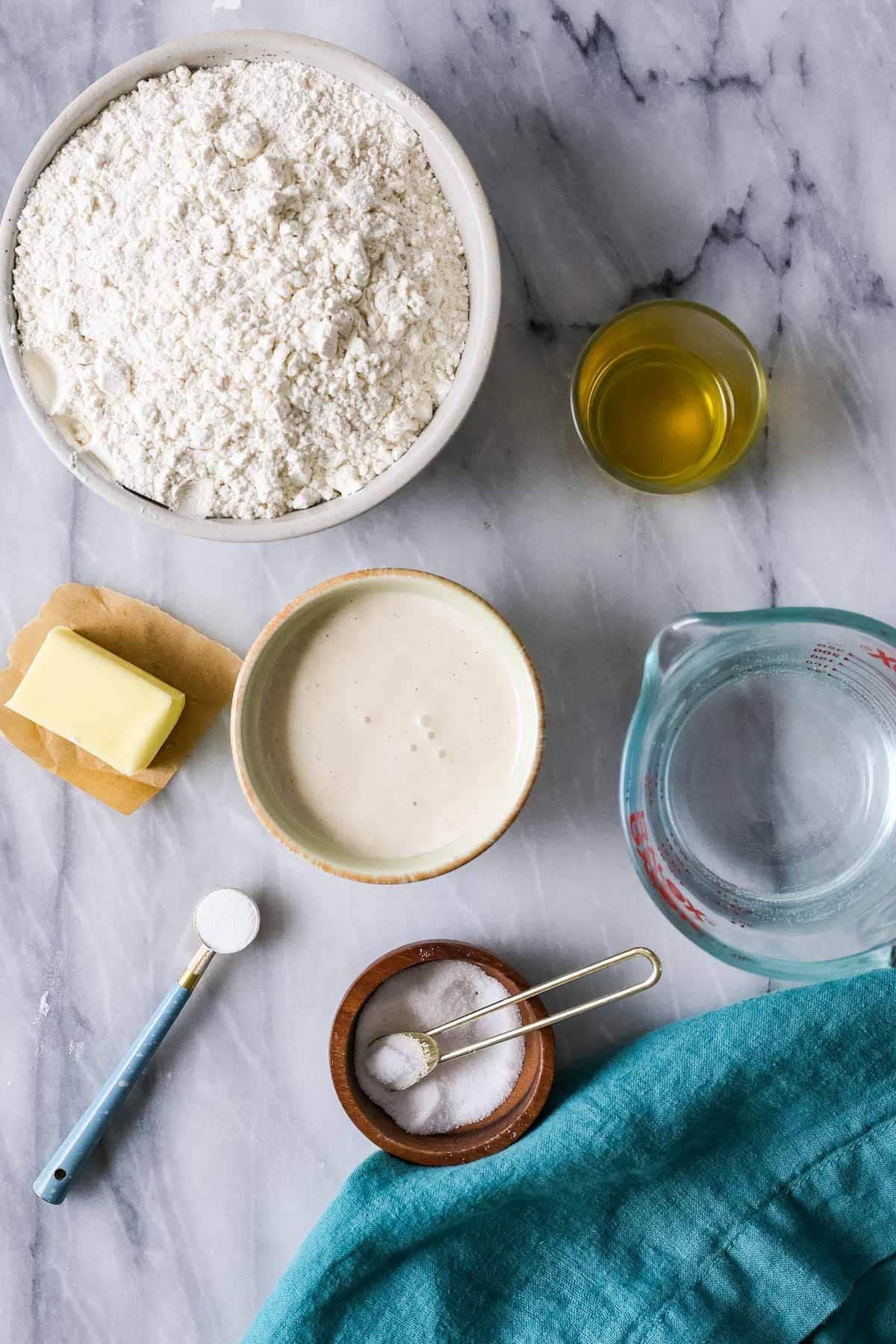 Overhead view of ingredients including flour, sourdough discard, butter, and more.