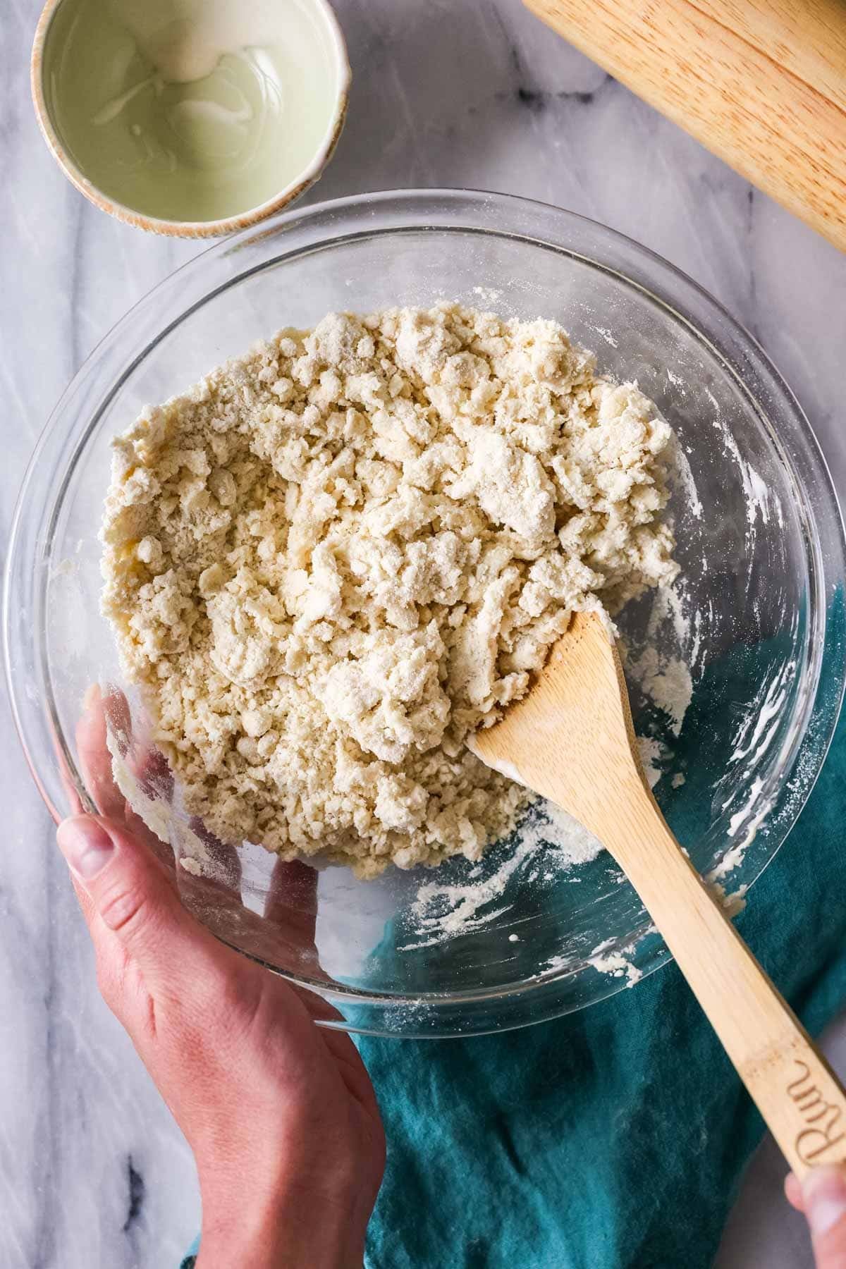 Overhead view of a crumbly dough after adding oil.