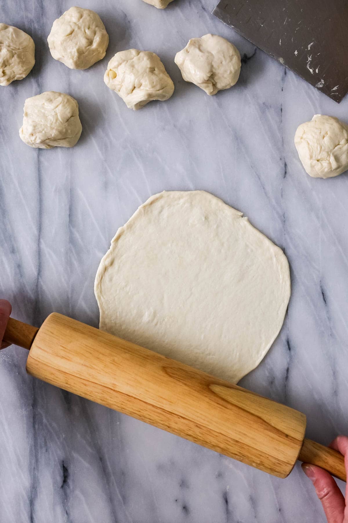 Rolling pin rolling out a sourdough tortilla.