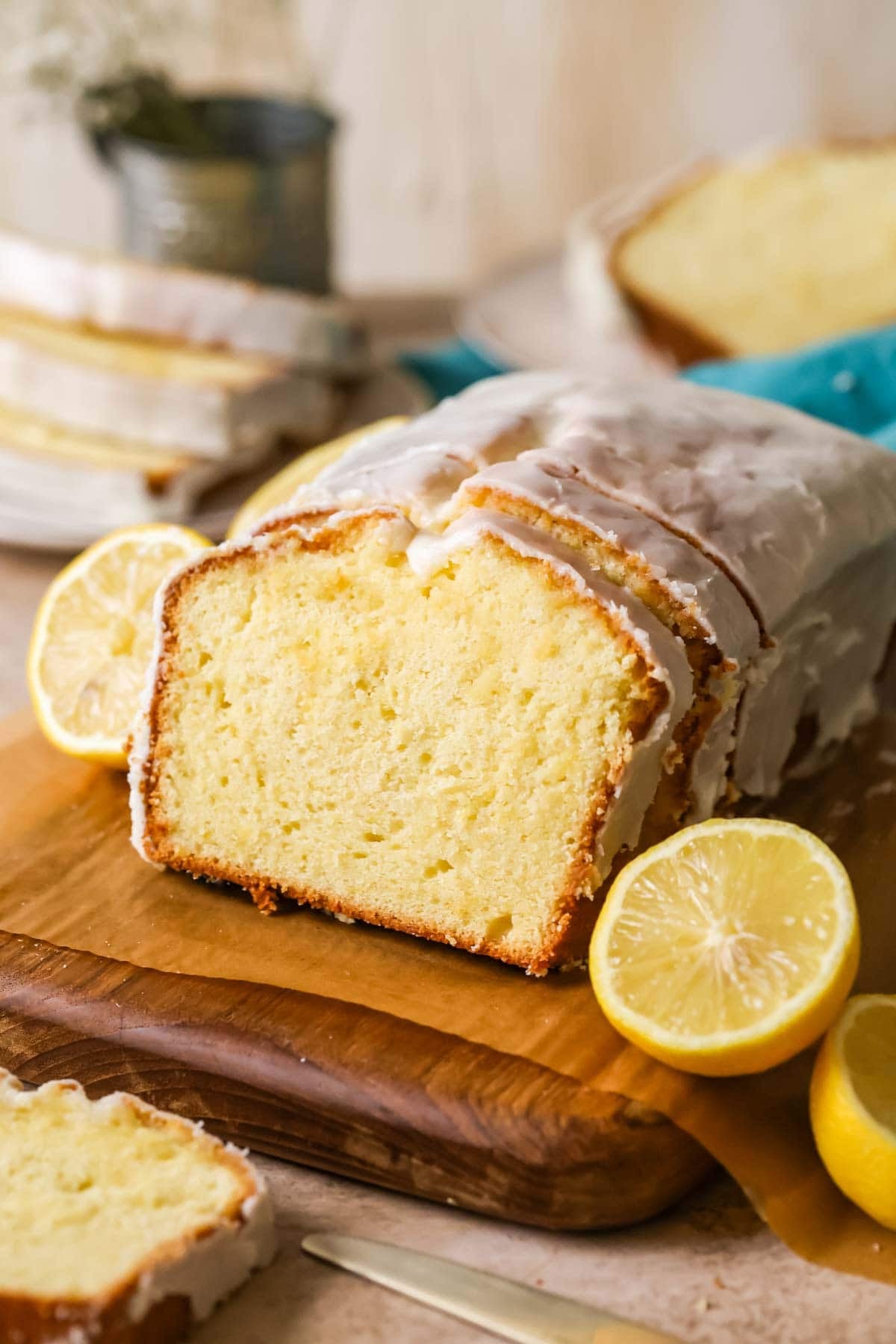 Lemon loaf with a few slices that have been cut and leaned against the loaf. 