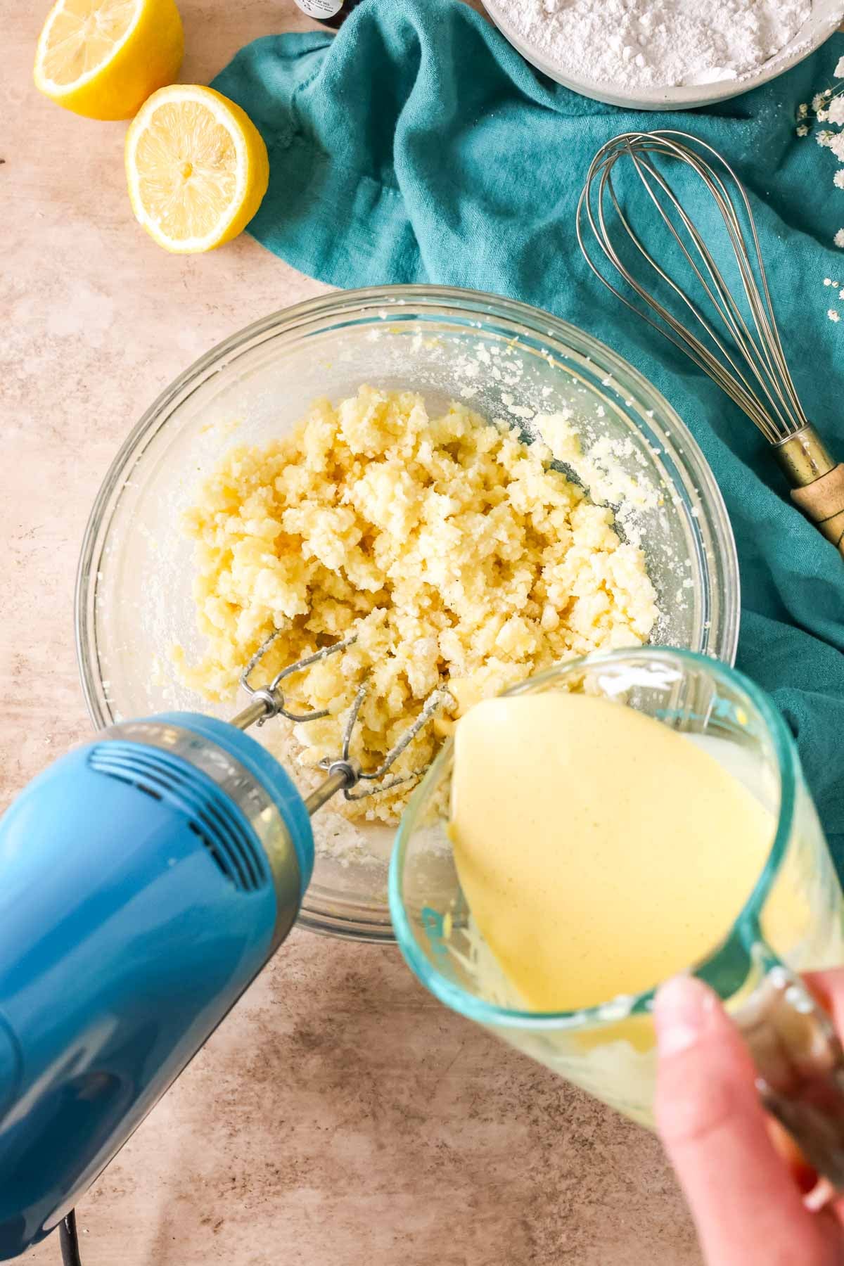 Pouring wet ingredients into creamed butter and sugar.