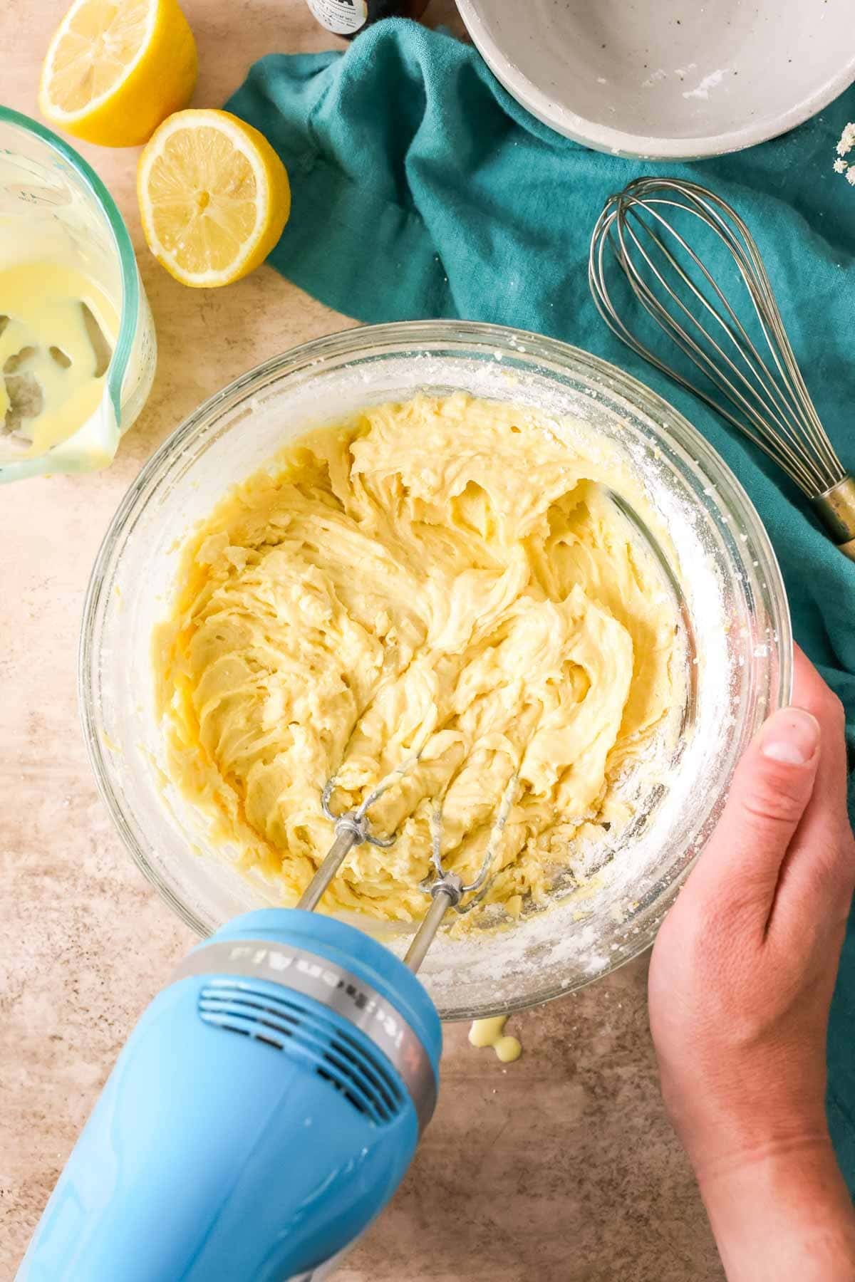 Mixing a pale yellow batter with an electric mixer.